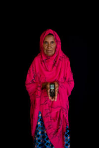 Older woman in red robe holding a mobile phone