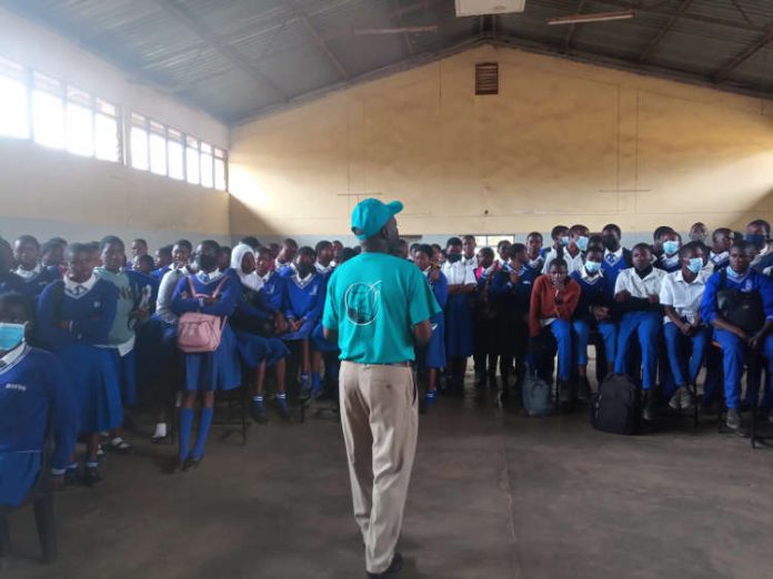 Facilitator stands before a group of public secondary school students